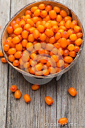 Buckthorn berry basket on wooden background. Stock Photo