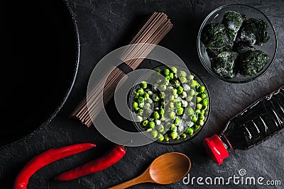 Buckwheat noodles, frozen spinach and peas, chili on a gray table Stock Photo