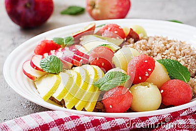 Buckwheat or porridge with fresh melon, watermelon, apple and pear. Stock Photo