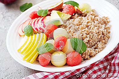 Buckwheat or porridge with fresh melon, watermelon, apple and pear. Stock Photo