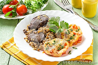 Buckwheat with stewed chicken liver and tomatoes baked with cheese Stock Photo