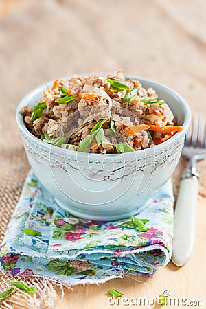 Buckwheat, stewed with meat, carrots and onions on a light background Stock Photo
