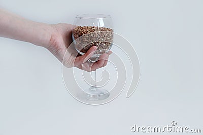 Buckwheat in a wine glass instead of wine in hand, proper nutrition and a sober lifestyle Stock Photo