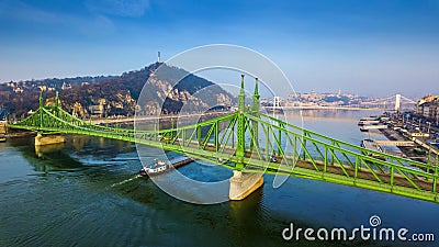 Budapest, Hungary - Aerial panoramic view of beautiful Liberty Bridge Szabadsag Hid with barge going on River Danube Editorial Stock Photo