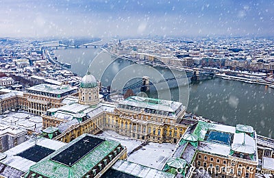 Budapest, Hungary - Aerial panoramic view of the snowy Buda Castle Royal Palace from above with the Szechenyi Chain Bridge Stock Photo