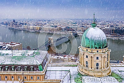 Budapest, Hungary - Aerial view of the dome of the snowy Buda Castle Royal Palace from above with the Szechenyi Chain Bridge Stock Photo