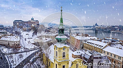 Budapest, Hungary - Catholic church with snowy Buda district, Buda Castle Royal Palace, Varkert Bazaar, Szechenyi Chain Bridge Stock Photo