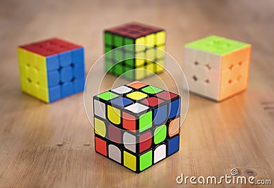 Budapest, Hungary; 9 february 2019: Several Rubik cubes intelligence toys unsolved, in a wood table Editorial Stock Photo