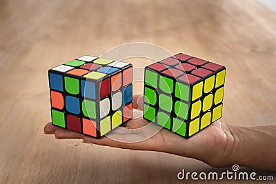 Budapest, Hungary; 9 february 2019: Several Rubik cubes intelligence toys unsolved, in a wood table Editorial Stock Photo