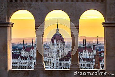 Budapest, Hungary - The Hungarian Parliament building at sunrise looking through old stone windows Stock Photo