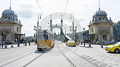 Budapest / Hungary - July 29 2019: Liberty Bridge or Freedom Bridge and yellow train in Budapest, Hungary. Cars crossing in the Editorial Stock Photo