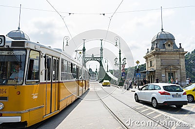 Budapest / Hungary - July 29 2019: Liberty Bridge or Freedom Bridge and yellow train in Budapest, Hungary. Cars crossing in the Editorial Stock Photo