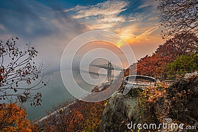 Budapest, Hungary - Lookout on Gellert Hill with Liberty Bridge Szabadsag Hid, fog over River Danube, colorful sky and clouds Stock Photo