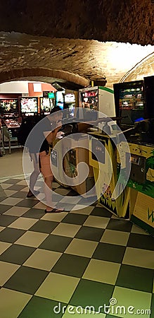 Budapest, Hungary - 2019.0619.: Old retro flipper arcade game machines, young Asian man shooting Editorial Stock Photo