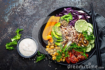 Buddha bowl dish with brown rice, avocado, pepper, tomato, cucumber, red cabbage, chickpea, fresh lettuce salad and walnuts. Healt Stock Photo