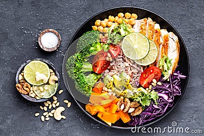 Buddha bowl dish with chicken fillet, brown rice, avocado, pepper, tomato, broccoli, red cabbage, chickpea, fresh lettuce salad, p Stock Photo