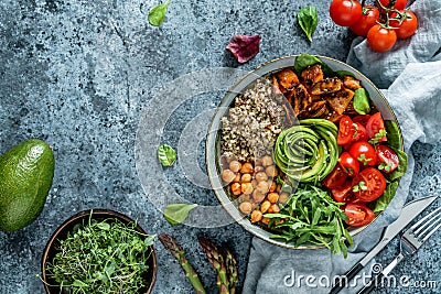 Buddha bowl salad with baked sweet potatoes, chickpeas, quinoa, tomatoes, arugula, avocado, sprouts on light blue background Stock Photo