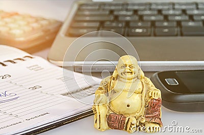 Buddha statue in front of office equipment symbolizing stress reduction and mindfulness Stock Photo