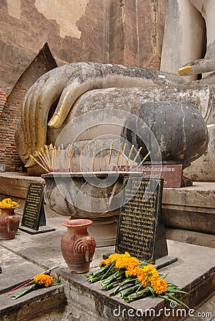 Buddha statue hand and offerings at Wat Si Chum in Sukhothai Historical Park. Thailand Stock Photo