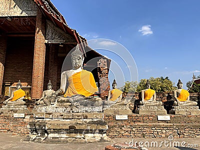 Buddha statues seated outside the main pagoda of Wat Yai Chaimongkol, Ayutthaya Stock Photo