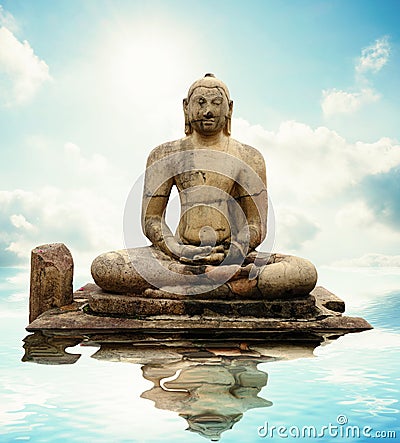 Buddha stone statue with water reflection. Stock Photo