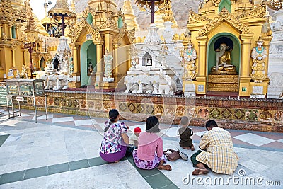 Buddhist family devotees prays to statue of Buddha Editorial Stock Photo