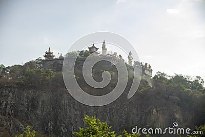 Buddhist giant statue on a massive hill with old buildings and churches Stock Photo