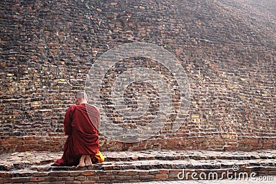 Buddhist monk at Buddha's cremation stupa in a foggy morning, Kushinagar, India Editorial Stock Photo