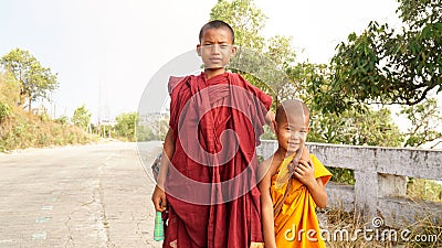 Buddhist Monk Children walking down on an empty road at the Kyaiktiyo Golden Rock Pagoda in near Yangon, Burma Editorial Stock Photo