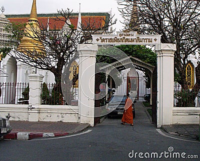 A Buddhist monk enters one of the gates of the Royal Cemetery of the Wat Ratchabophit temple in Bangkok Editorial Stock Photo