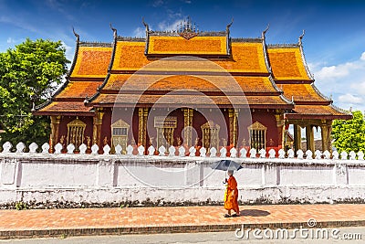 A Buddhist monk walks by the Wat Sen Temple in Luang Prabang, Laos Editorial Stock Photo