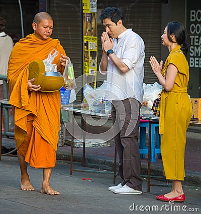 Buddhist monks collect offerings on a city street Editorial Stock Photo