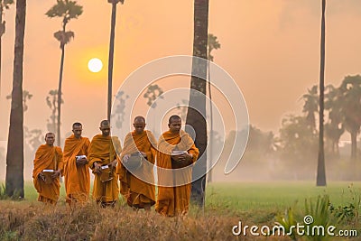 Buddhist monks going about to receive food from villager in morning in Thailand Stock Photo