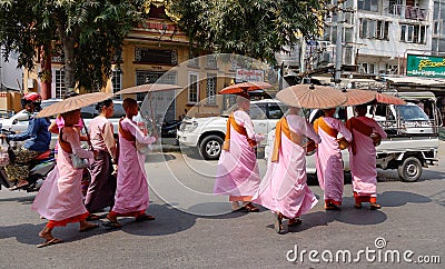 Buddhist nuns walking for morning alms on street in Mandalay, Myanmar Editorial Stock Photo