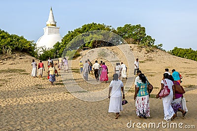 Buddhist pilgrims walk towards the stupa on the beach at Pottuvil in Sri Lanka. Editorial Stock Photo