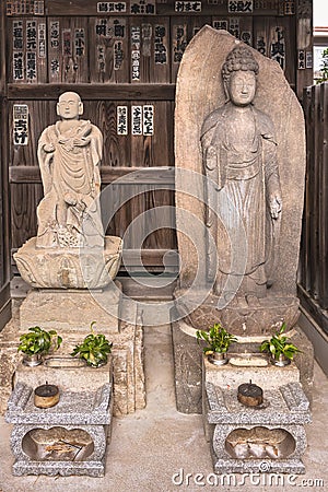 Buddhist sculptures of bodhisattva Kosodate Jizo and Buddha Shaka Nyorai in Tamonji temple. Editorial Stock Photo