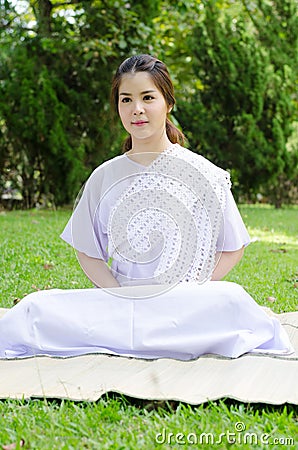 Buddhist thai woman happy with white clothing sitting for meditation Stock Photo