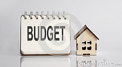 BUDGET words written in an office notebook with wooden house. Financial Business concept Stock Photo