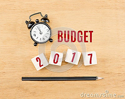 Budget 2017 year on wood cube with pencil and clock top view on Stock Photo