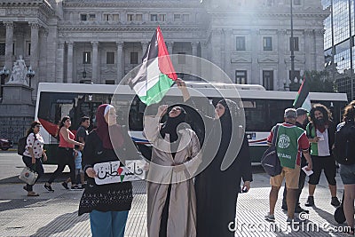 Women raising a Palestinian flag in Argentina, in solidarity with Palestine Editorial Stock Photo