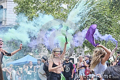 Women waving green and violet smoke flares in the air during 8M feminist strike Editorial Stock Photo