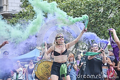 Women waving green and violet smoke flares in the air during 8M feminist strike Editorial Stock Photo