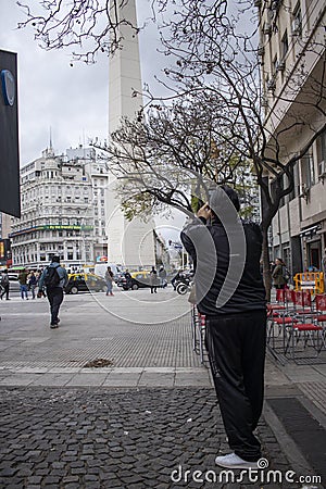 Tourist taking a picture of the Obelisk of the city of Buenos Aires. Argentina Editorial Stock Photo