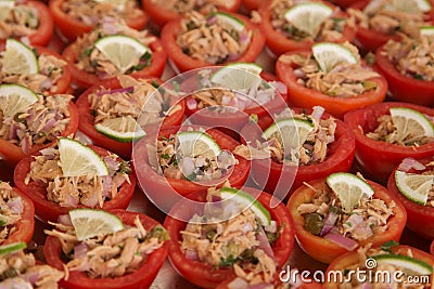 Buffet appetizer: tomatoes stuffed with canned tuna and onions, garnished with a slice of lemon Stock Photo