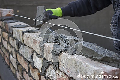 Build a brick wall, bricklaying spreading a bed joint Stock Photo