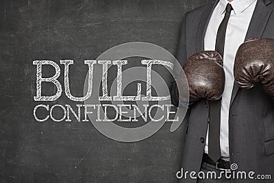 Build confidence on blackboard with businessman Stock Photo