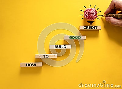 Build good credit symbol. Wooden blocks, words How to build good credit. Beautiful beautiful yellow background, copy space. Stock Photo