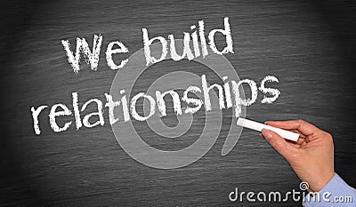 We build relationships - female hand with chalk writing text Stock Photo