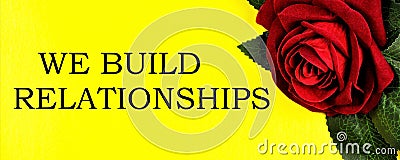 We build relationships - text inscription on the background of a red rose. Stock Photo