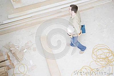 A builder carrying a tool box Stock Photo